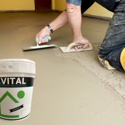 Homem a assentar piso de cimento cinzento claro com ferramentas e balde de impermeabilizante VITAL