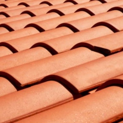 Telhado com telhas de cerâmica vermelha em camadas onduladas.