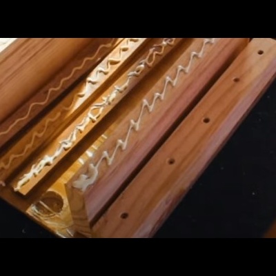 Molduras de madeira com cola branca em padrão ziguezague sobre superfície preta