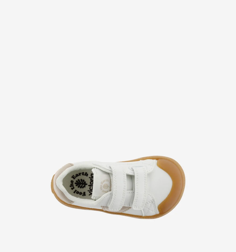 Sapatilha infantil branca com sola castanha e fechos de velcro.