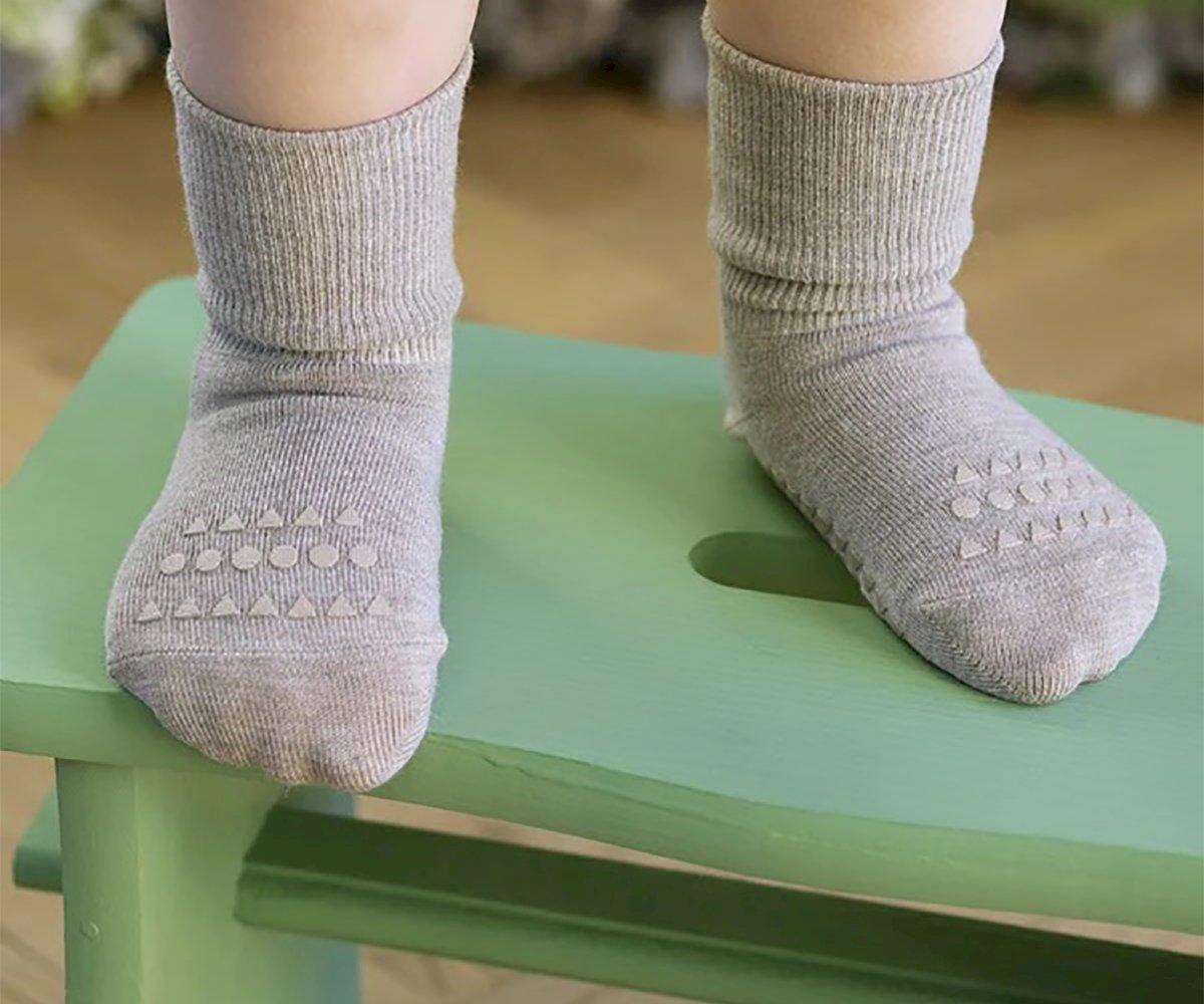 Meias cinzentas de malha com padrão antiderrapante na sola em banco verde claro
