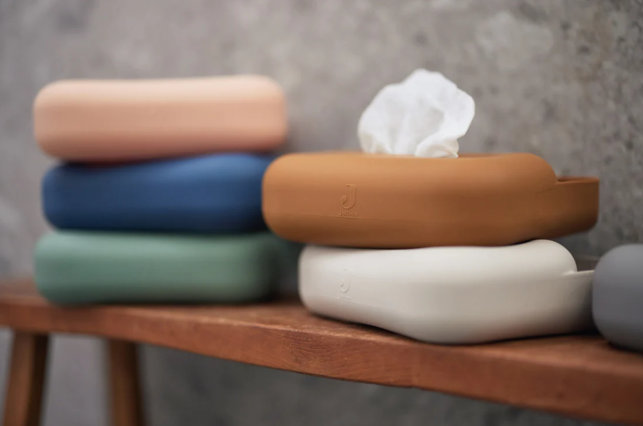 Caixas dispensa-lenços em madeira coloridas sobre suporte de madeira