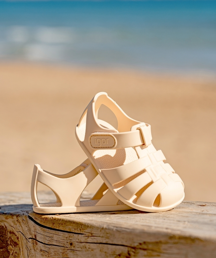 Sandálias de plástico creme para criança na praia