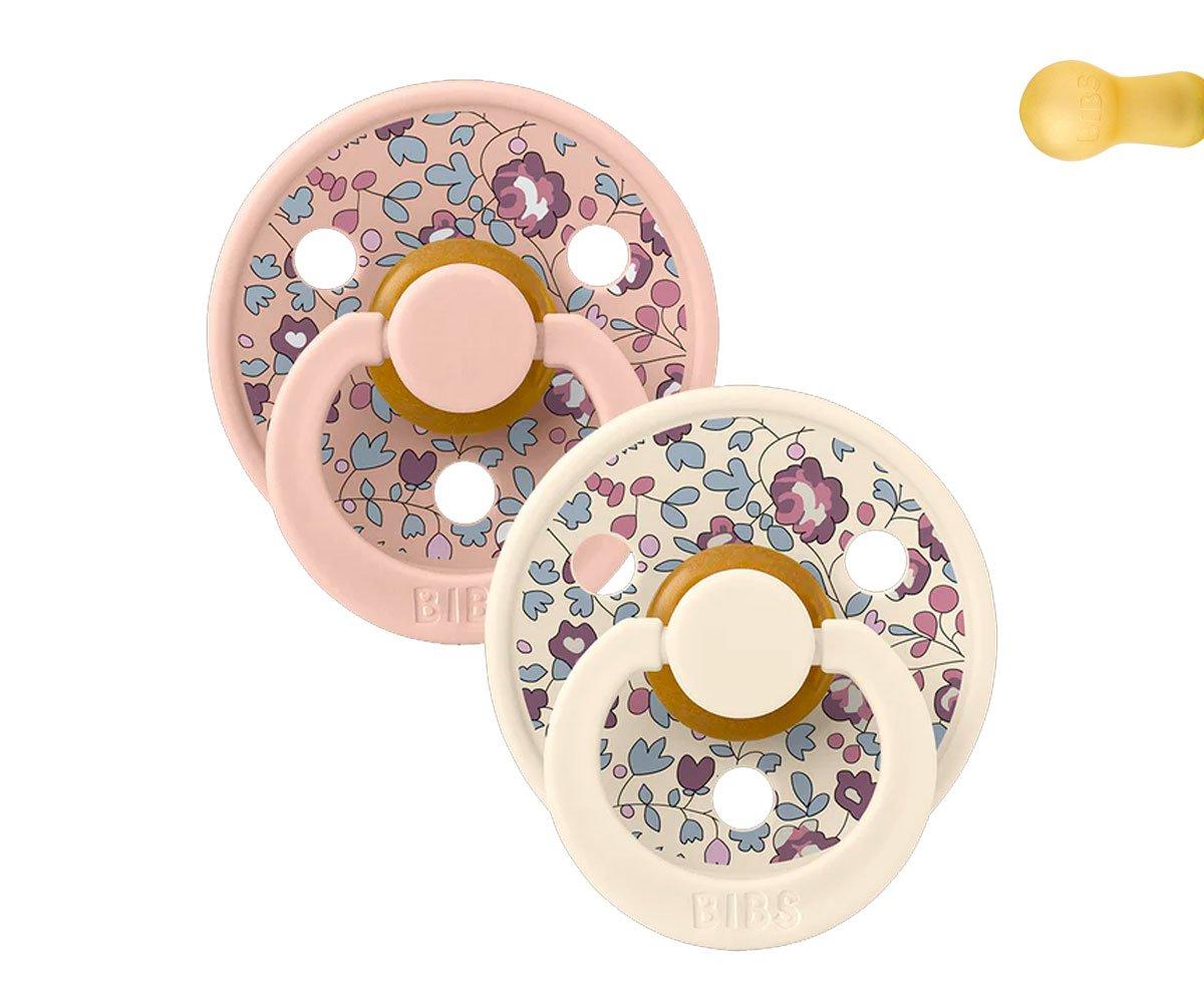 Duas chupetas de tecido com padrão floral e suportes em rosa claro e bege