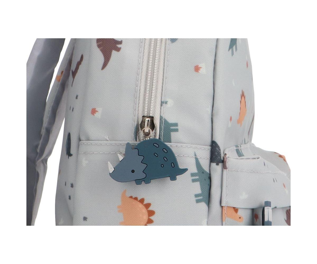 Mochila infantil cinza claro com padrão de dinossauros e puxador de fecho em forma de dinossauro azul
