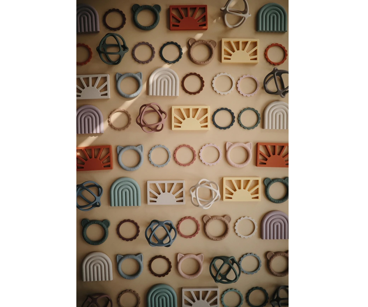 Peças decorativas geométricas coloridas distribuídas ordenadamente sobre fundo bege