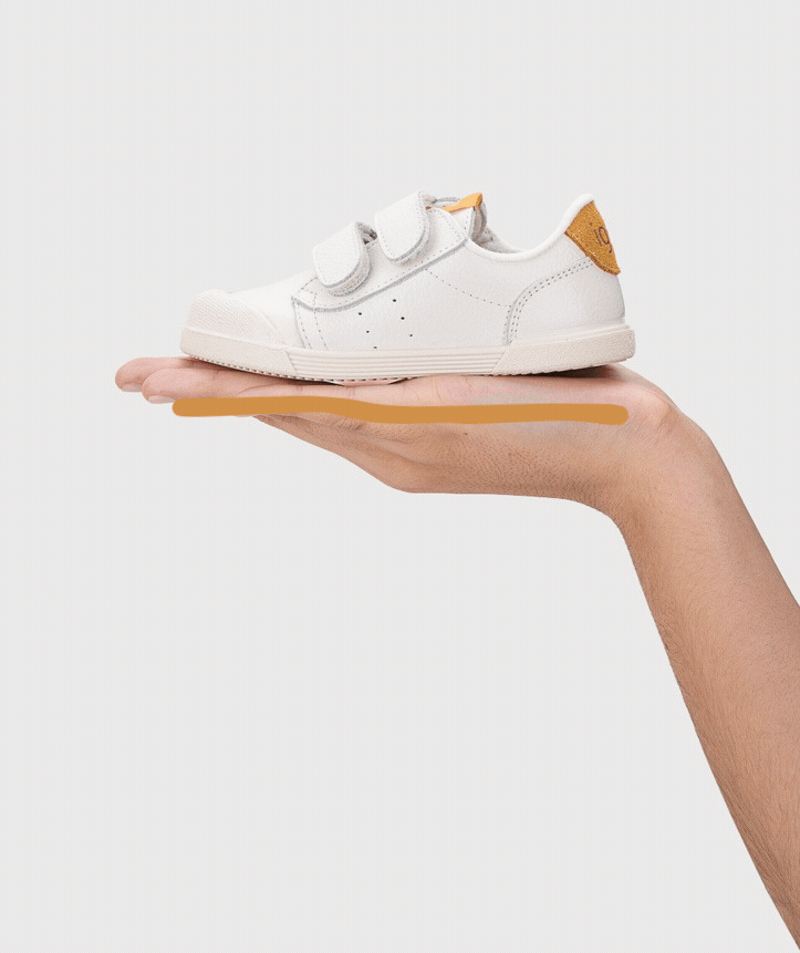 Tênis infantil branco com velcro e detalhe castanho na parte traseira na palma da mão