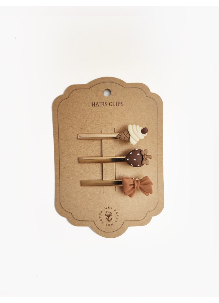 Conjunto de três presilhas de cabelo decorativas sobre cartolina castanha