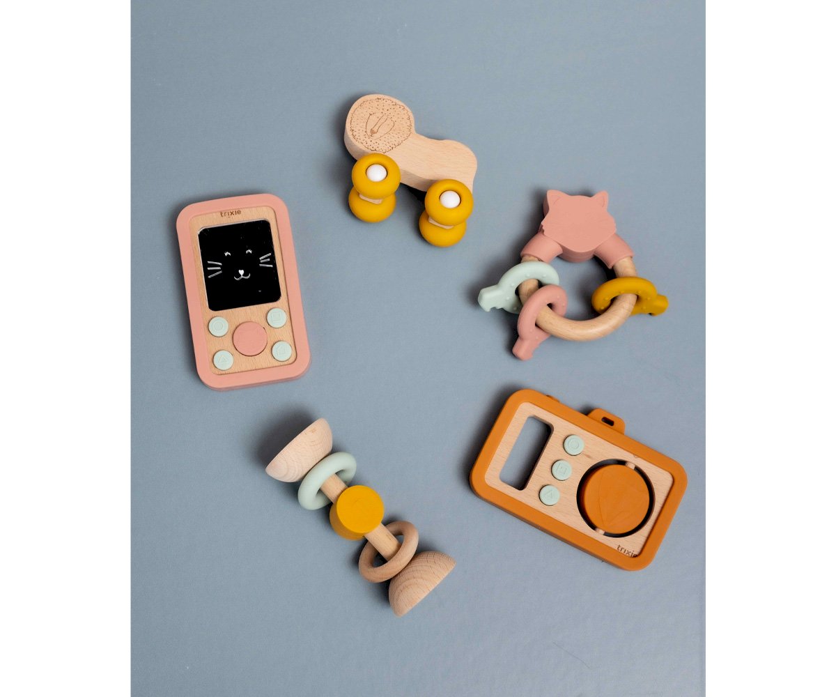 Brinquedos em silicone e madeira coloridos sobre fundo cinza