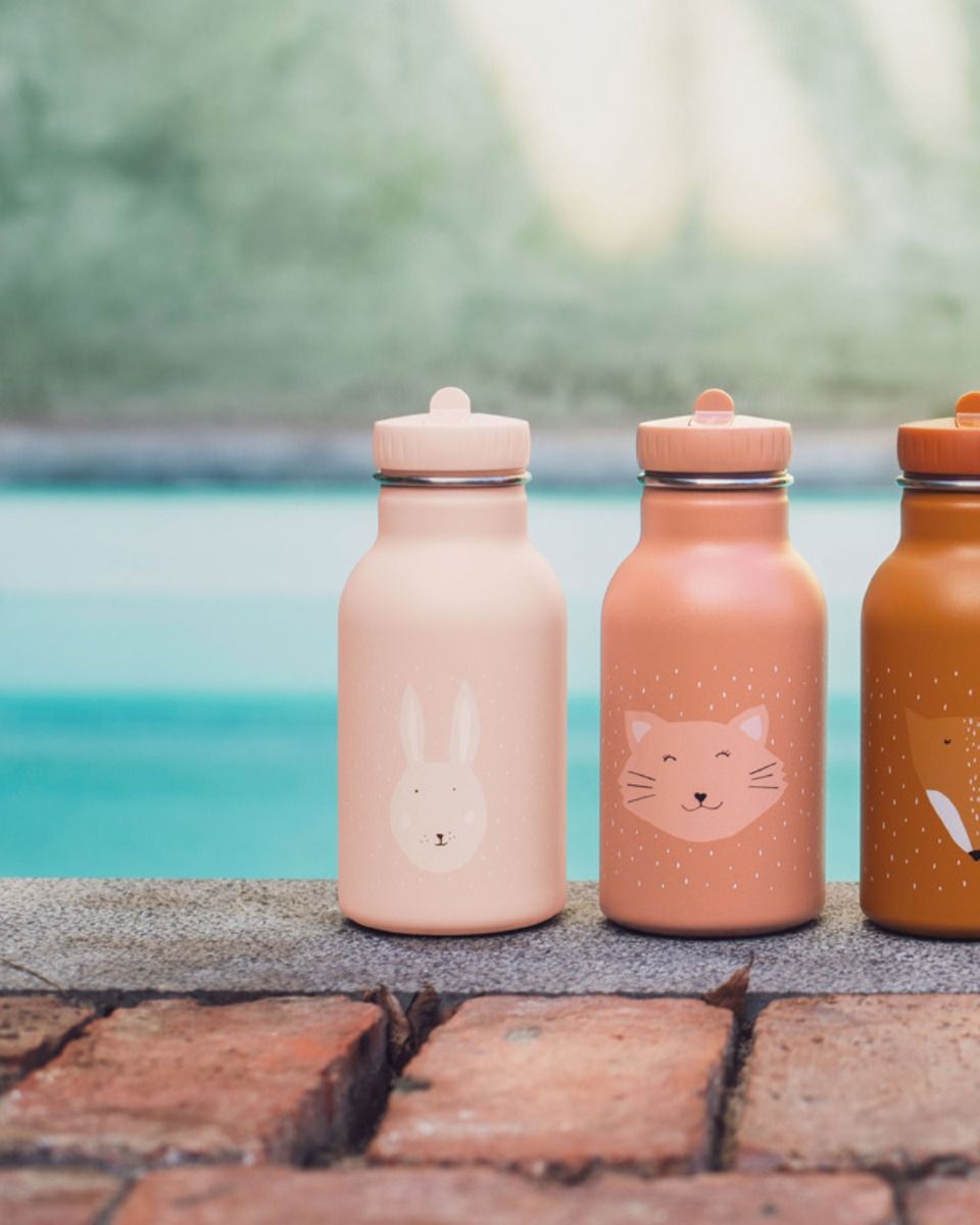 Três garrafas metálicas coloridas com desenhos de animais junto a uma piscina.