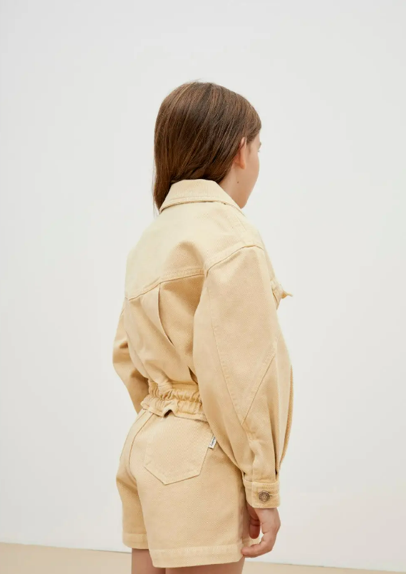 Conjunto bege de casaco e calções de algodão em criança vista de costas