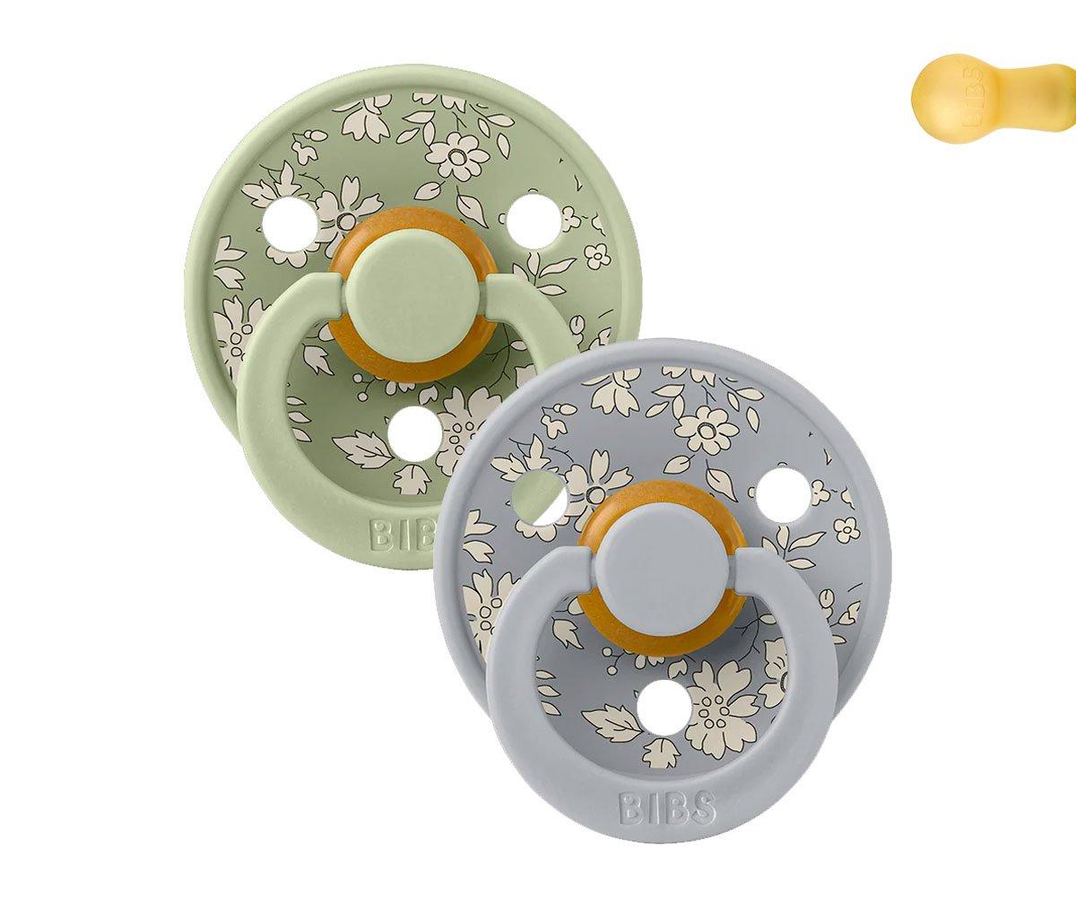 Dois chupetas BIBS com padrão floral, uma verde e outra cinza