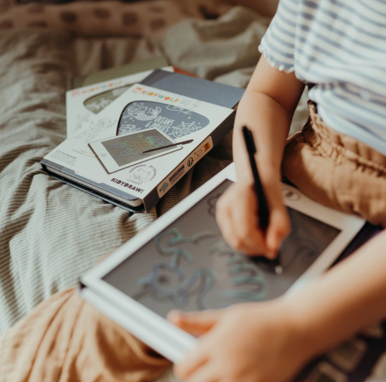 Tablet de escrita digital com caneta e embalagens próximas