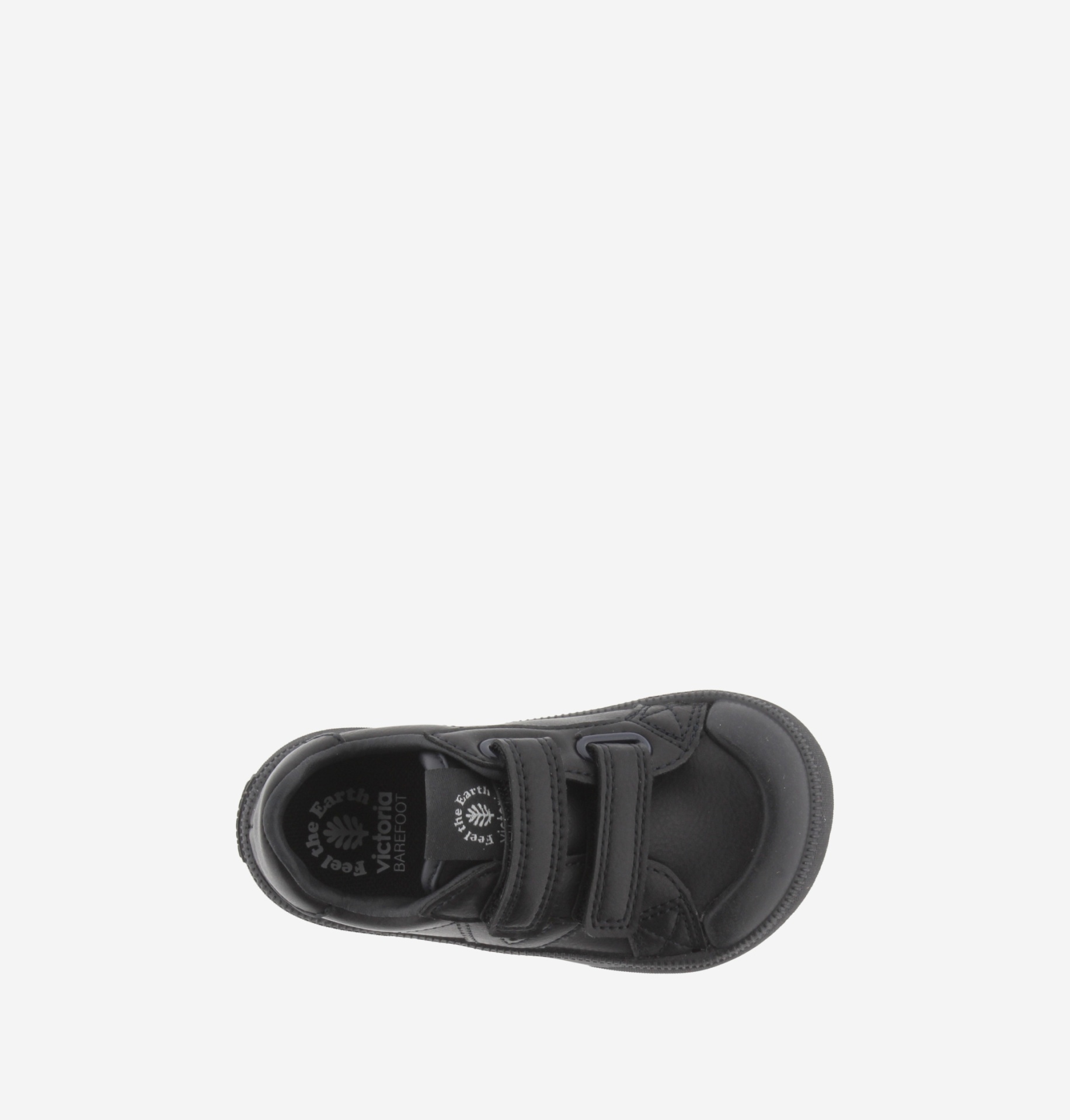 Sapatilha preta de criança vista de cima sobre fundo branco