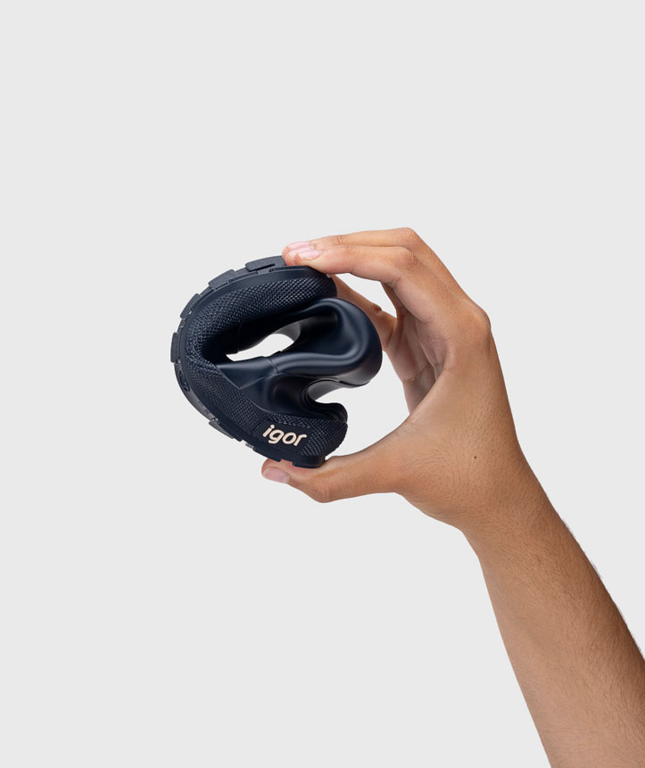 Sandália preta flexível de borracha com sola antiderrapante e marca 'igor' mostrada numa mão