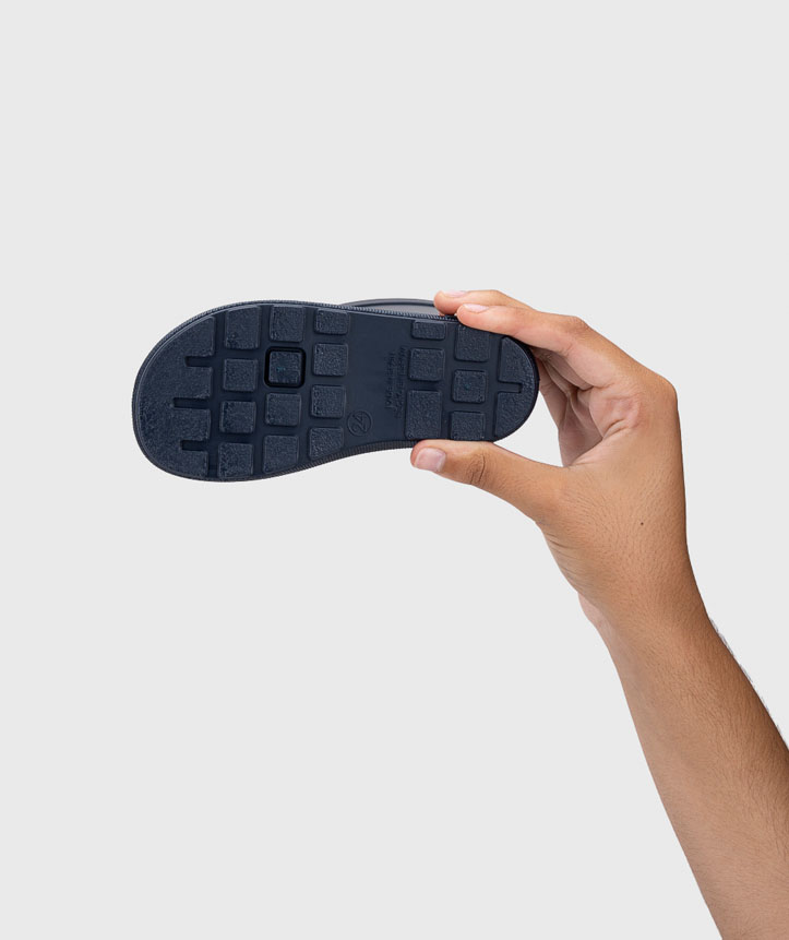 Sola de sapato infantil preta segurada por uma mão