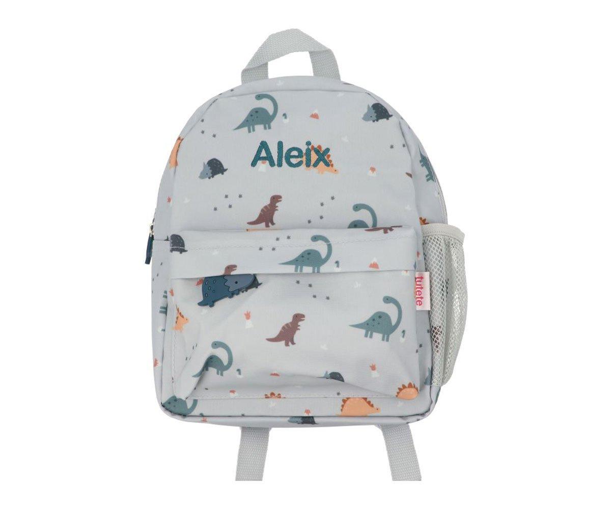 Mochila cinza clara com padrões de dinossauros e nome Aleix bordado