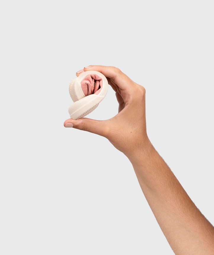 Mão a segurar faixa elástica bege enrolada