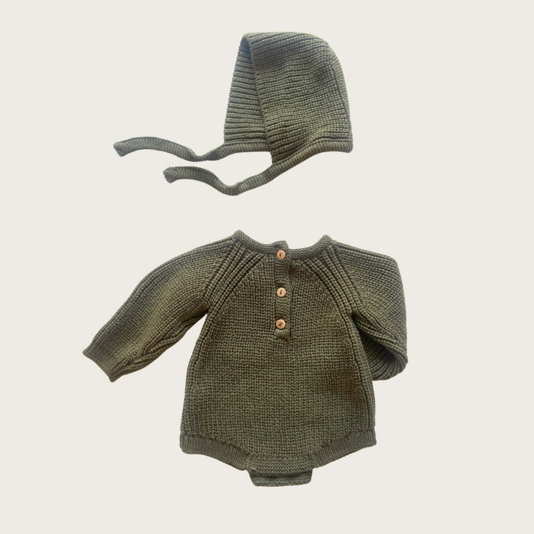 Conjunto de roupa de bebé em tricô verde com camisola e gorro.