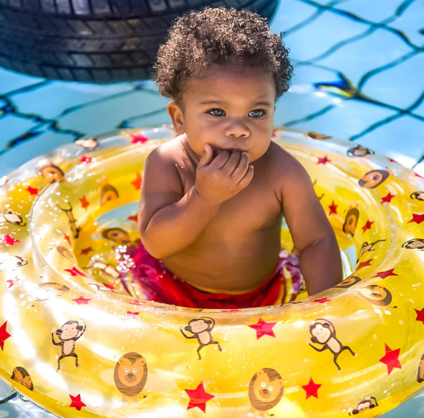 Bebé numa bóia insuflável amarela com padrões de animais na piscina
