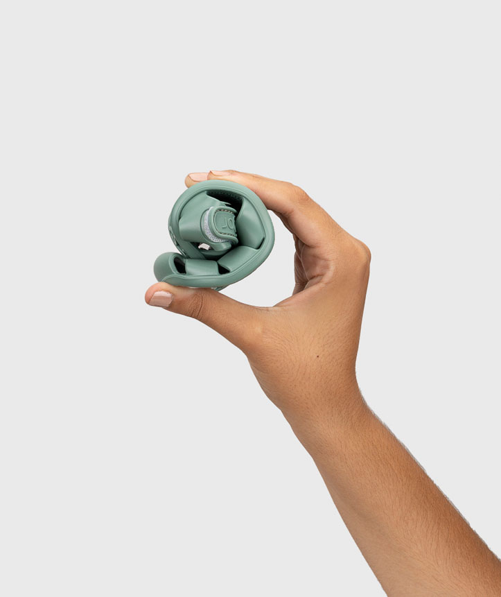 Ténis flexível verde-acinzentado segurado por uma mão