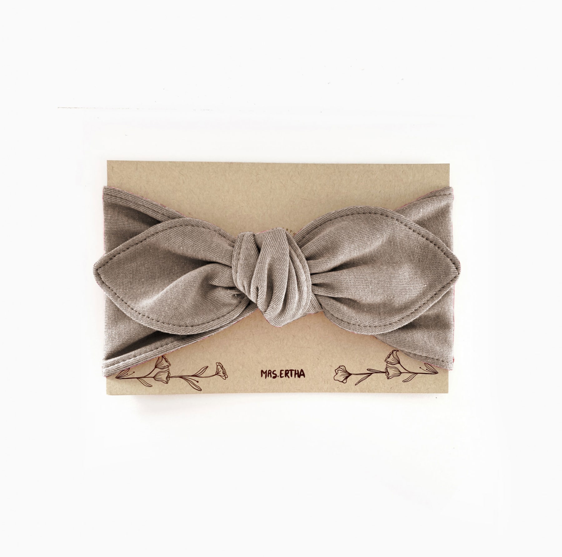 Faixa de cabelo cinzenta clara em embalagem de cartão bege com texto e flores desenhadas