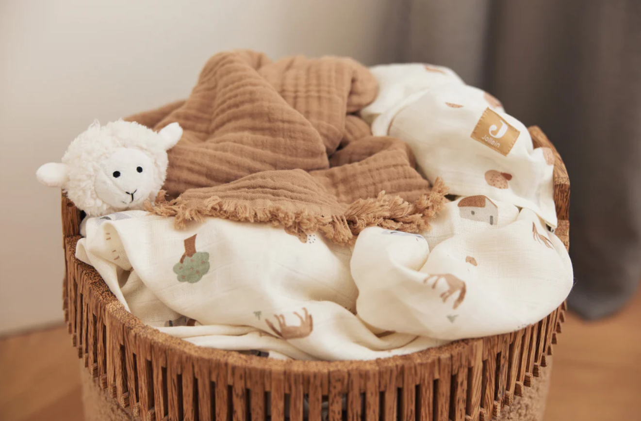 Cesto com manta bege estampada, manta castanha e peluche ovelha