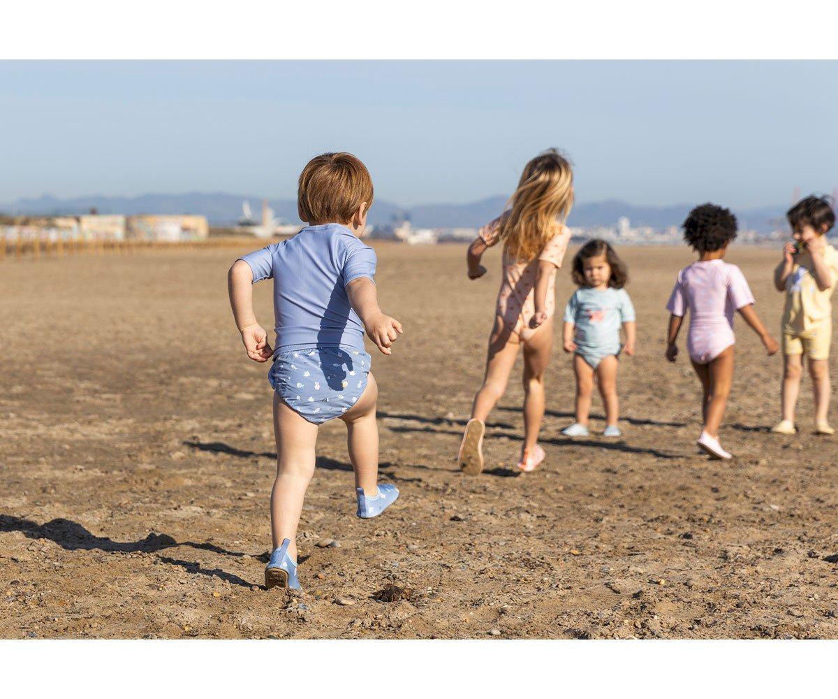 Crianças a brincar ao ar livre com roupa de banho colorida e padrões simples
