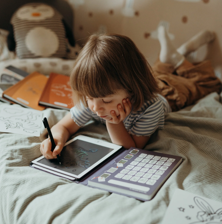 Criança a usar tablet para crianças com teclado ilustrado e caneta