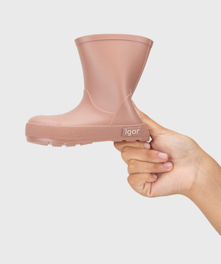 Bota infantil de borracha cor de rosa marca igor segurada pela mão