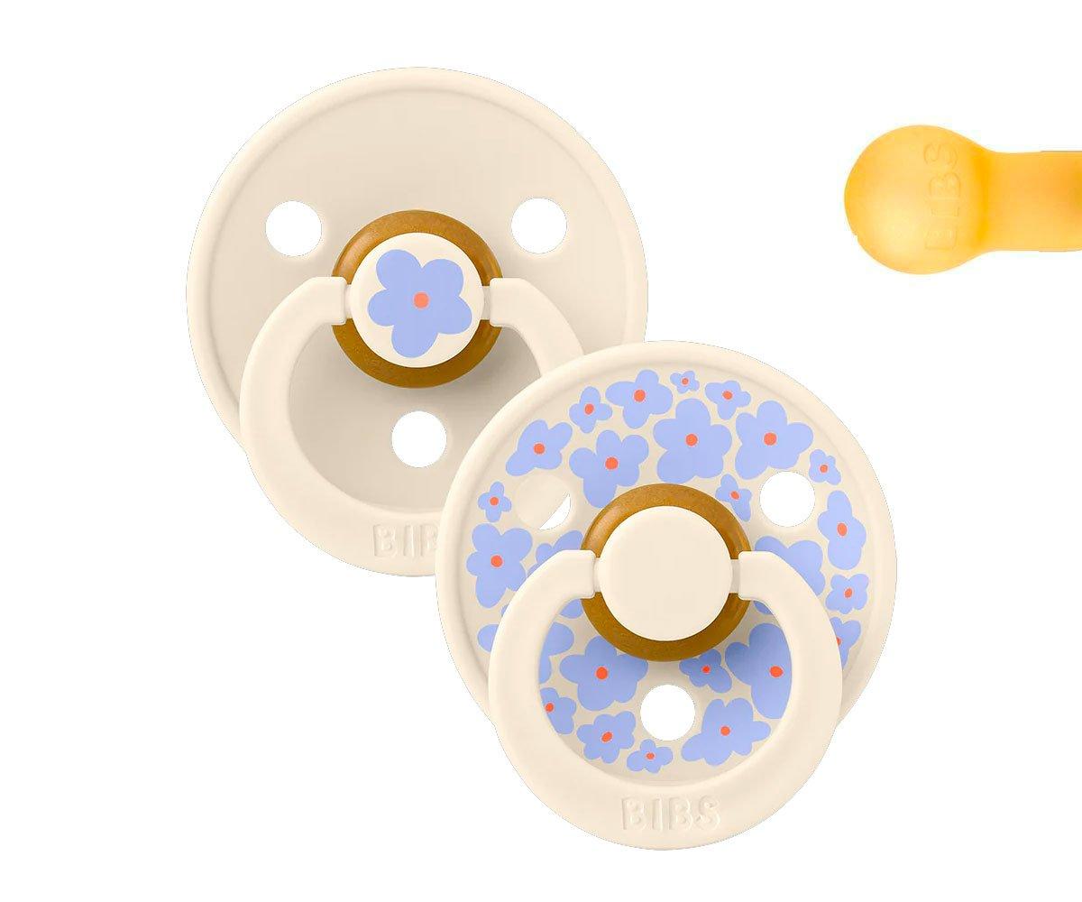 Duas chupetas brancas com flores azuis e lilás e anel branco