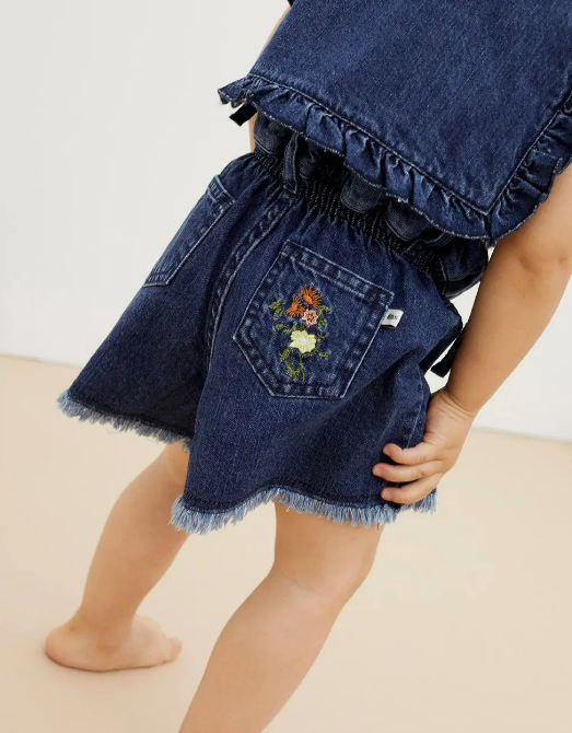 Calções de ganga azul escuro com bordado floral no bolso traseiro em criança