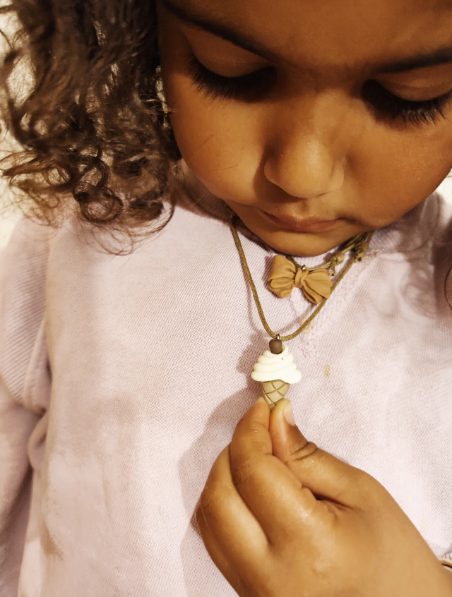Criança com colar de pingente em forma de gelado de casquinha