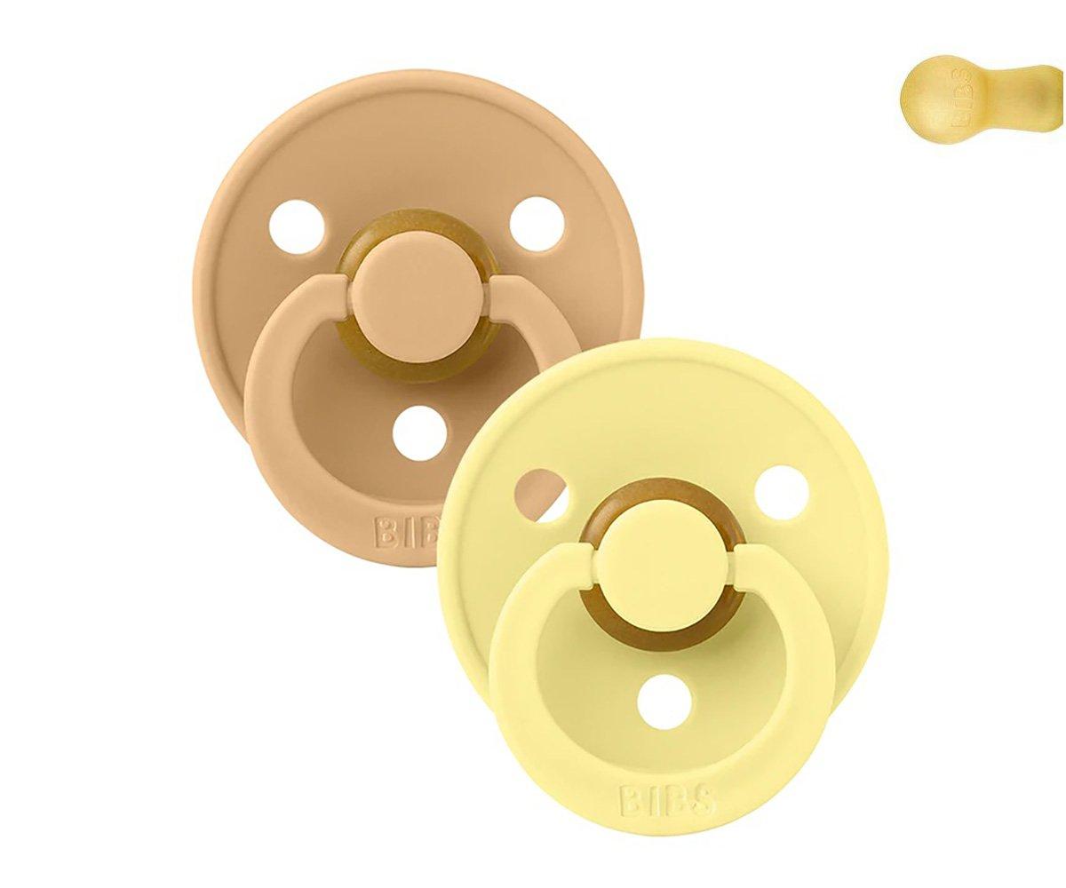 Duas chupetas BIBS bege e amarelo claro com três orifícios no escudo