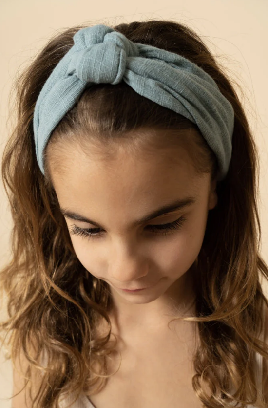 Faixa de cabelo azul clara com nó frontal em menina