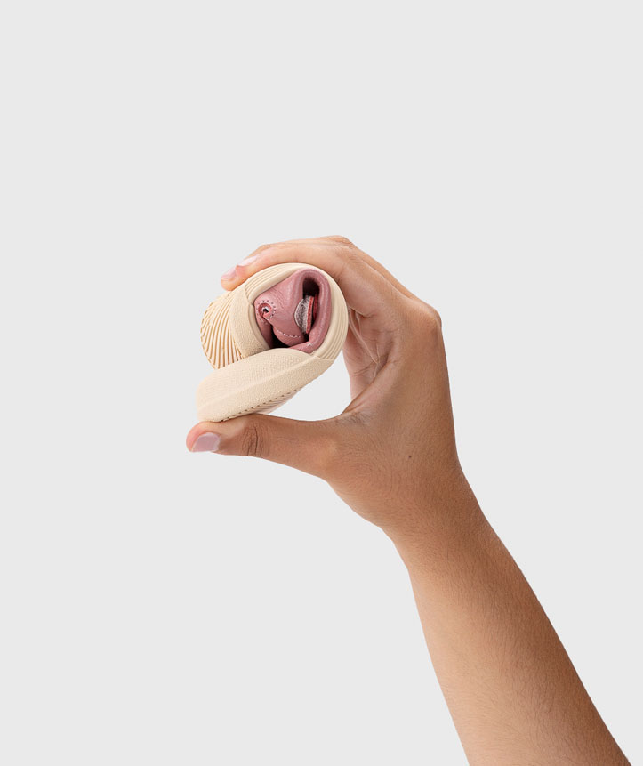 Mão a segurar dois pares de meias enrolados, bege e rosa, textura nervurada.