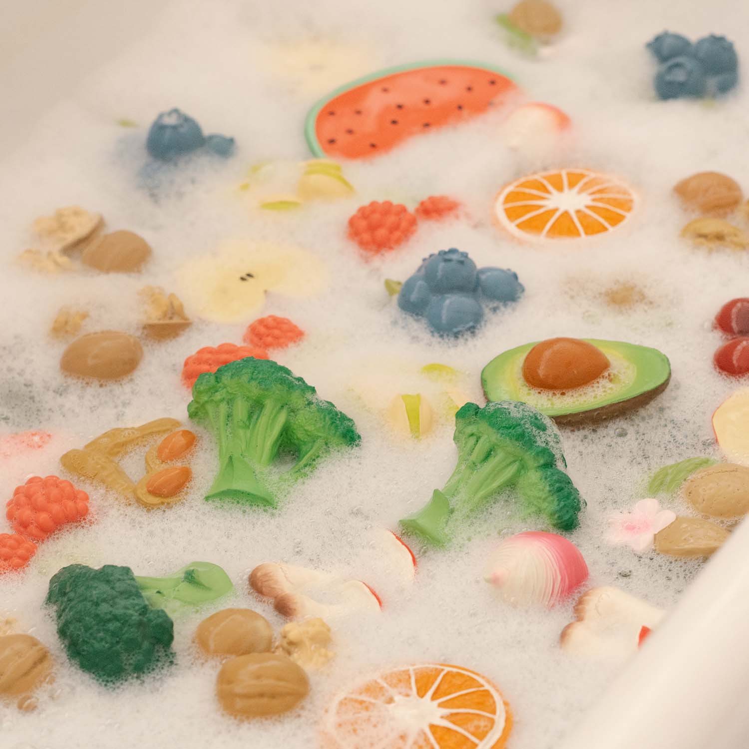 Brinquedos de comida flutuando em espuma branca