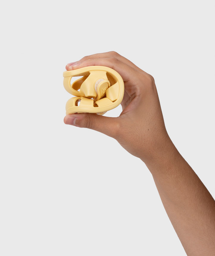 Mão segura um calçado amarelo dobrado