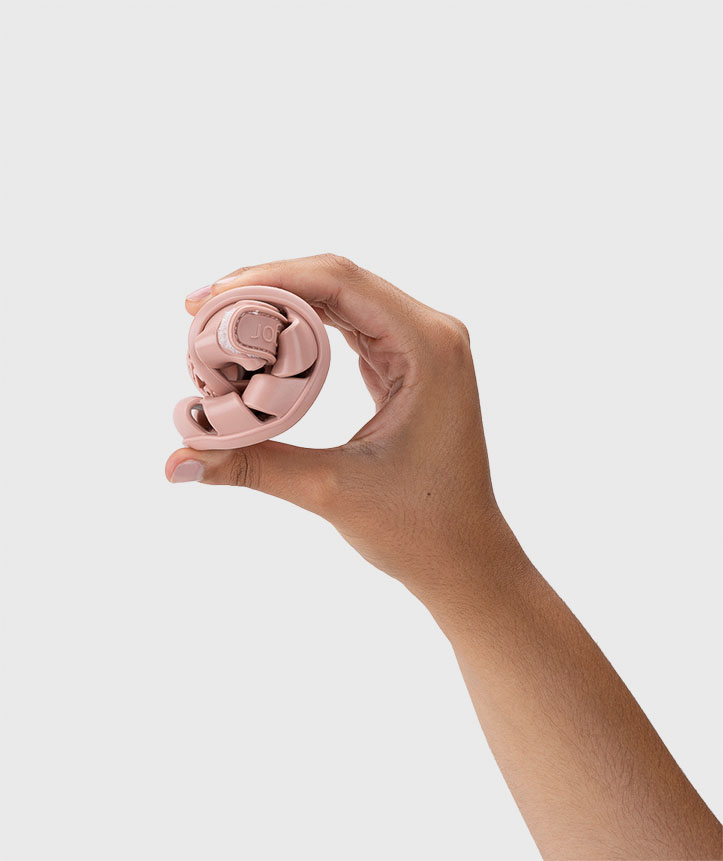 Mão segurando auscultadores wireless rosa dobrados