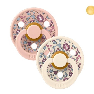 Duas chupetas de tecido com padrão floral e suportes em rosa claro e bege