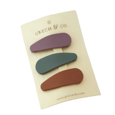 Conjunto de três presilhas de cabelo coloridas da marca GRECH & CO. em cartão branco.
