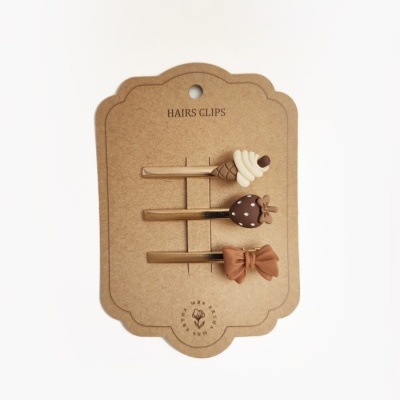 Conjunto de três presilhas de cabelo decorativas sobre cartolina castanha