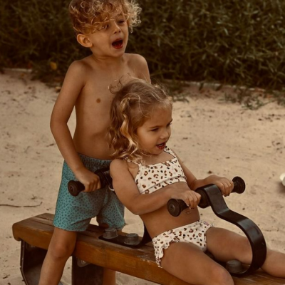 Criança e menina em gangorra de madeira ao ar livre