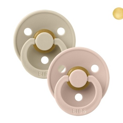 Duas chupetas BIBS redondas bege e rosa claro com anéis de silicone e botões de madeira