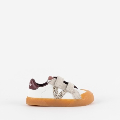 Sapatilha branca com sola laranja e detalhes em velcro e tecido bege.