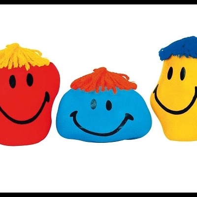 Três brinquedos coloridos com rostos sorridentes