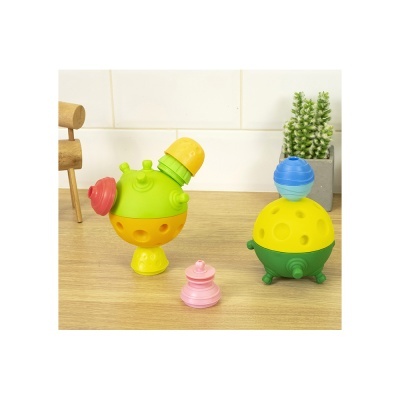 Brinquedos coloridos de plástico sobre superfície de madeira com planta ao fundo