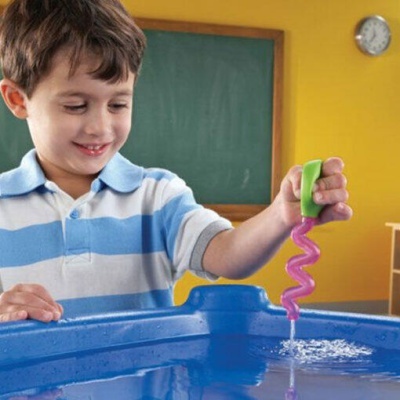 Menino a brincar com brinquedo de água espiral em tanque azul