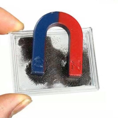 Imã em U azul e vermelho com limalha de ferro dentro de caixa transparente