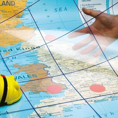 Brinquedo robô abelha amarelo e mapa do Reino Unido com mão interagindo